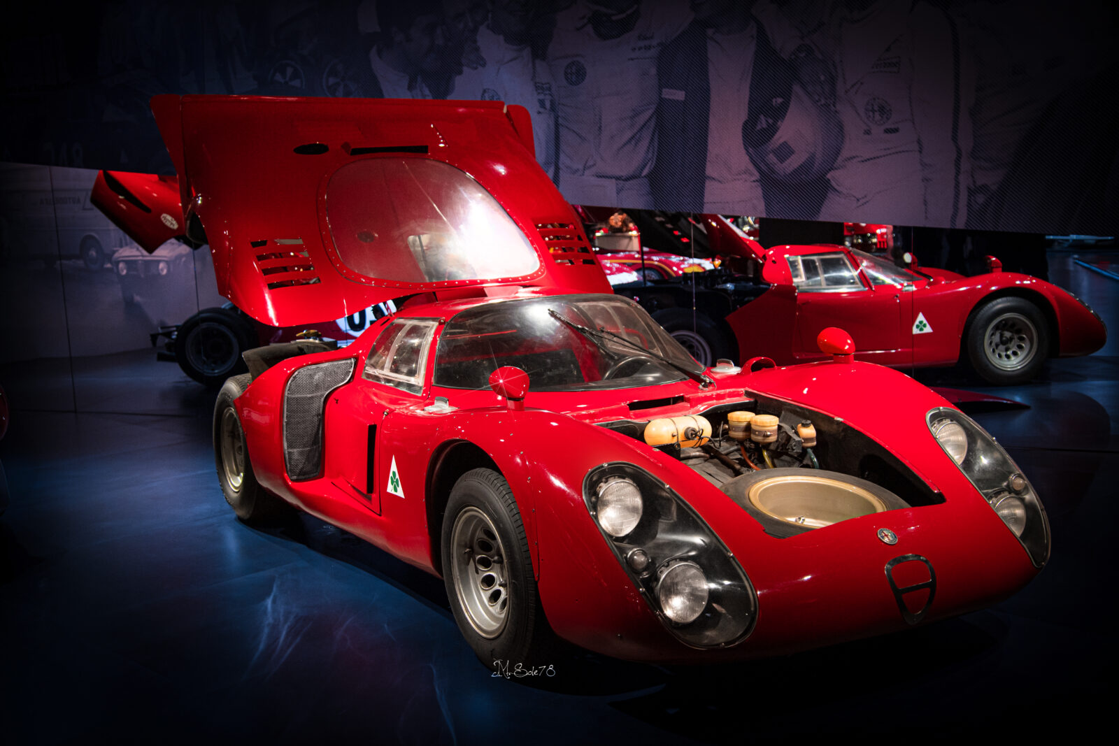 Alfa Romeo Tipo 33 rossa con cofano anteriore aperto e motore a vista, museo